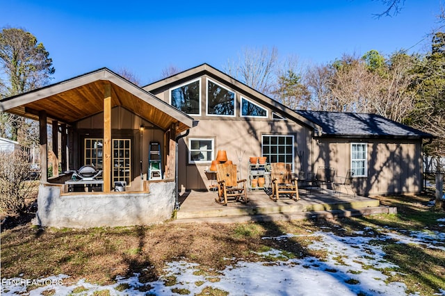 snow covered house with a wooden deck