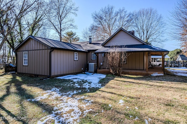 rear view of property featuring a lawn and central AC