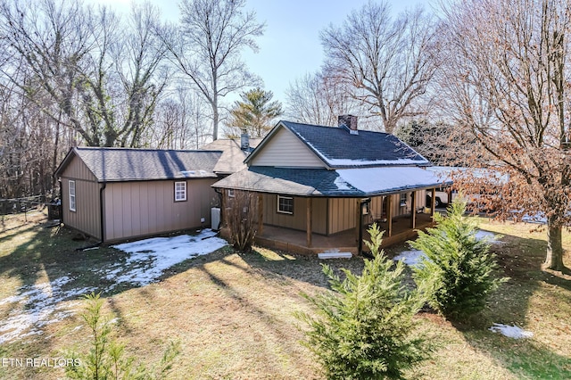 back of house featuring a lawn and a porch