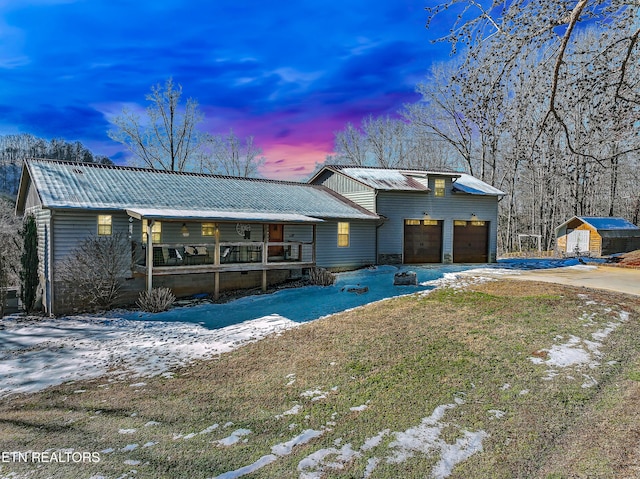 view of front of house featuring a yard, covered porch, and a garage