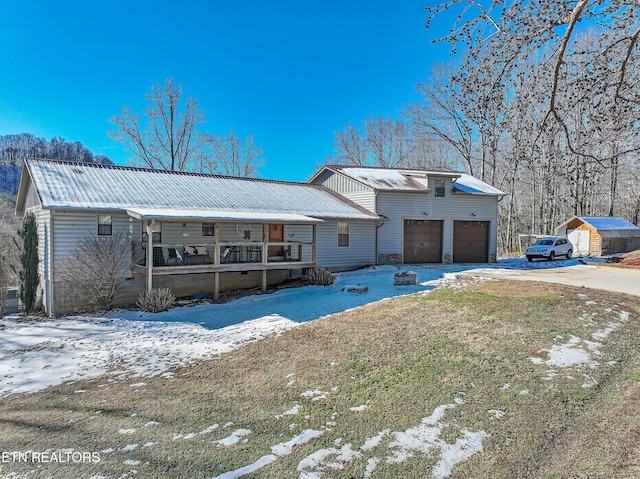 view of front of house with a yard, a porch, and a garage