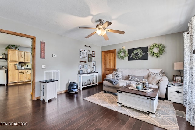 living room with ceiling fan, dark hardwood / wood-style flooring, and a textured ceiling