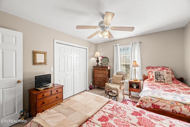 bedroom with a textured ceiling, ceiling fan, carpet, and a closet