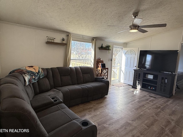 living room featuring a textured ceiling, hardwood / wood-style floors, ornamental molding, vaulted ceiling, and ceiling fan