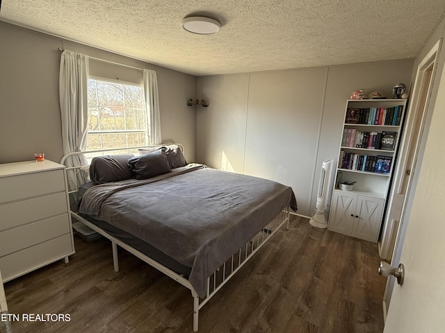 bedroom featuring dark wood-type flooring and a textured ceiling