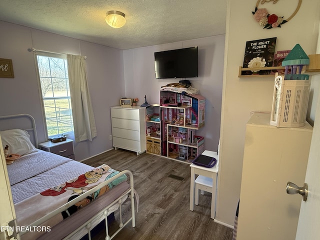 bedroom featuring a textured ceiling and dark hardwood / wood-style flooring