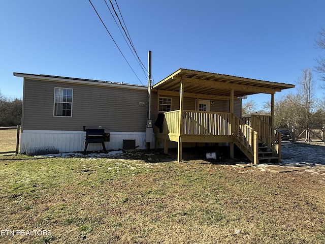 rear view of property with a wooden deck, a lawn, and central air condition unit