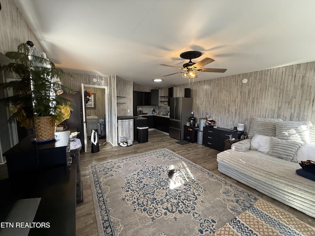 living room featuring dark wood-type flooring and ceiling fan