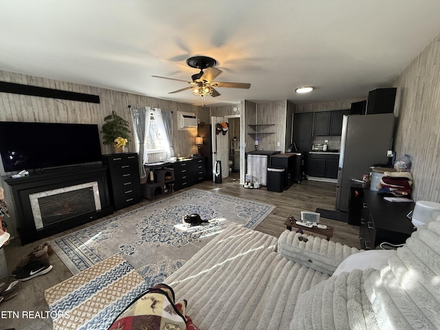 living room featuring ceiling fan, dark hardwood / wood-style flooring, and a wall mounted air conditioner