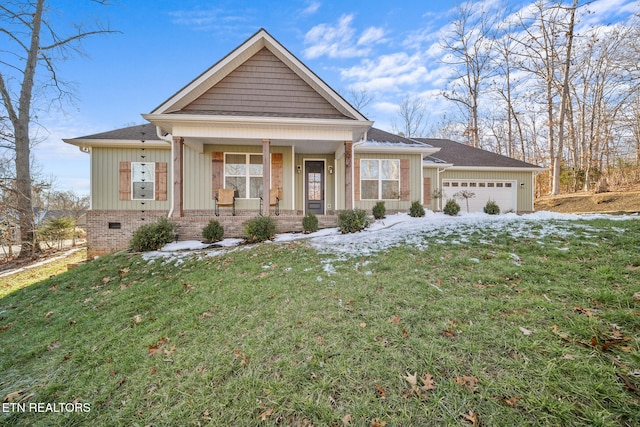 view of front of property with a yard, covered porch, and a garage