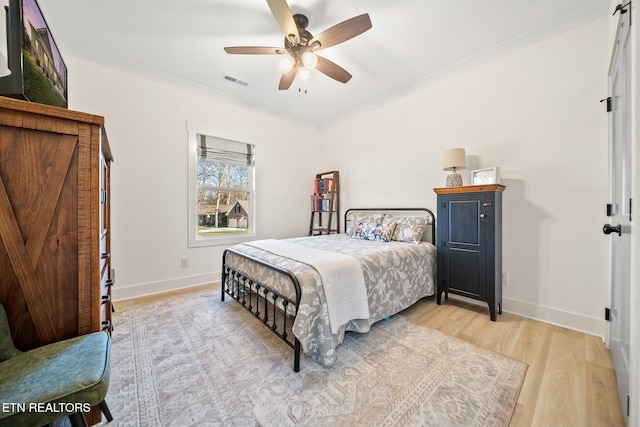 bedroom featuring ceiling fan, light hardwood / wood-style flooring, and ornamental molding