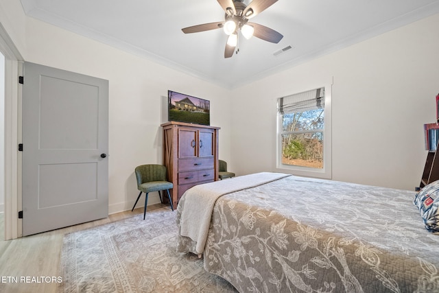 bedroom with ceiling fan, ornamental molding, and light hardwood / wood-style floors