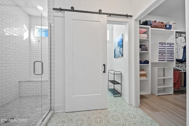 bathroom featuring a shower with shower door and hardwood / wood-style flooring