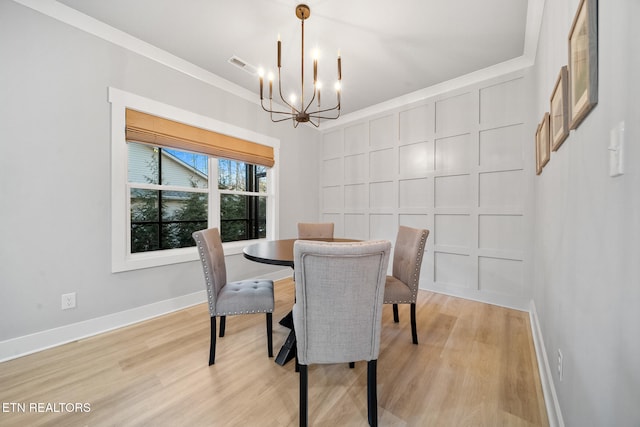 dining area featuring an inviting chandelier, crown molding, and light hardwood / wood-style flooring