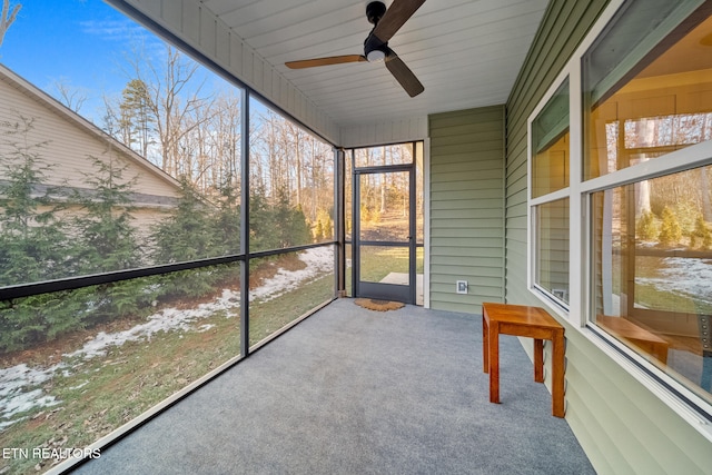 unfurnished sunroom with ceiling fan