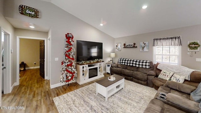 living room with hardwood / wood-style flooring and vaulted ceiling