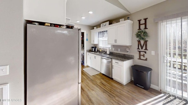 kitchen featuring stainless steel appliances, plenty of natural light, sink, and white cabinets