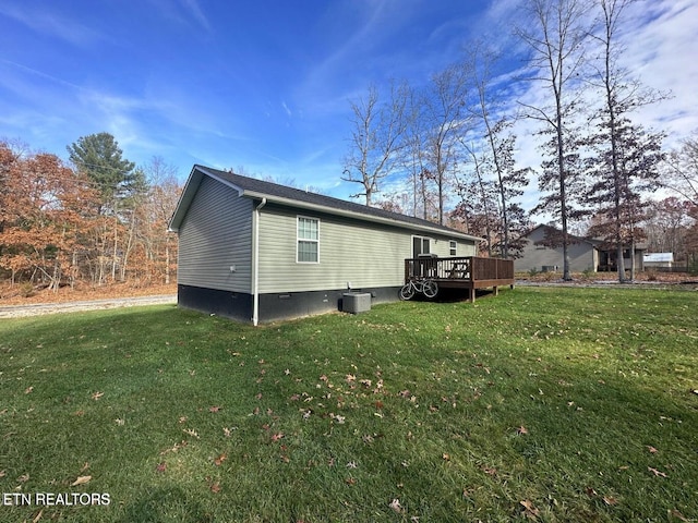 view of side of property featuring central air condition unit, a deck, and a yard