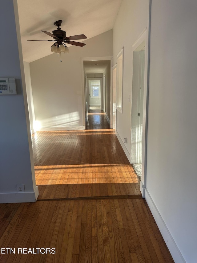 corridor featuring dark hardwood / wood-style flooring and vaulted ceiling