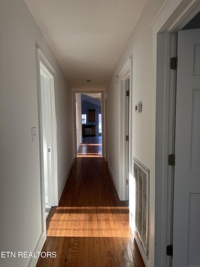 corridor with hardwood / wood-style flooring