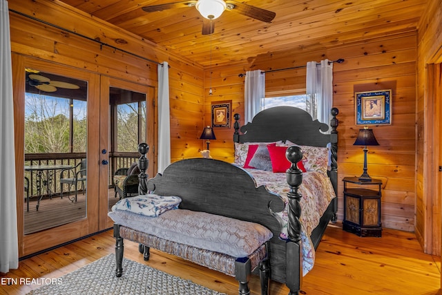 bedroom with wood walls, access to exterior, ceiling fan, wooden ceiling, and light hardwood / wood-style flooring