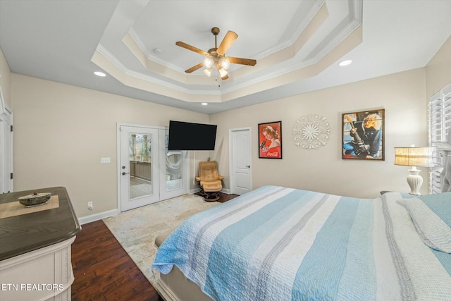 bedroom with ceiling fan, access to outside, a tray ceiling, dark wood-type flooring, and ornamental molding