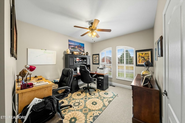 carpeted office space with ceiling fan