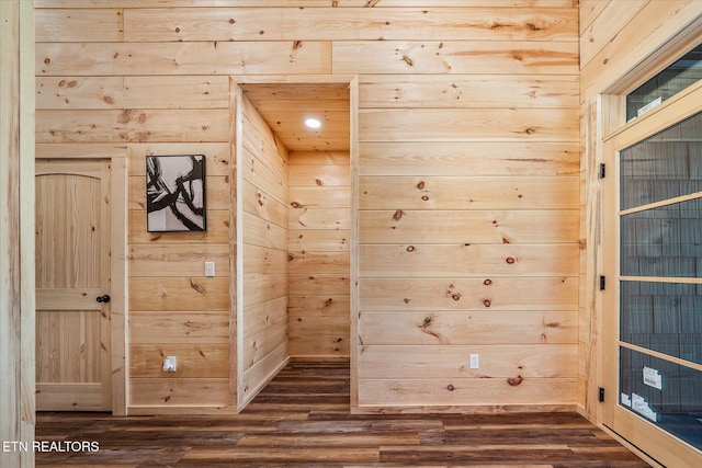 interior details featuring hardwood / wood-style floors and wood walls