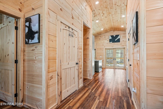 hall featuring lofted ceiling, wooden walls, french doors, dark hardwood / wood-style flooring, and wooden ceiling