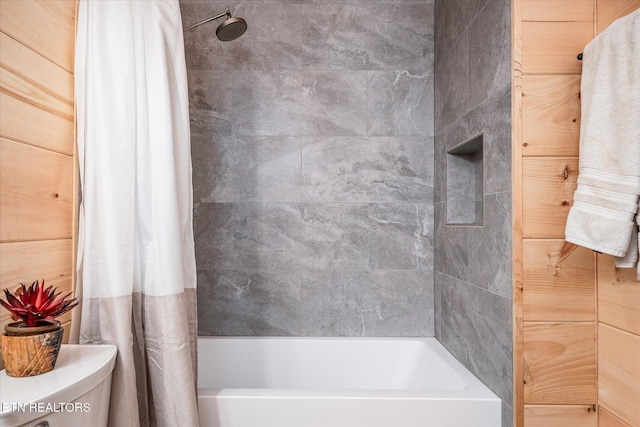 bathroom featuring toilet and shower / bathtub combination with curtain