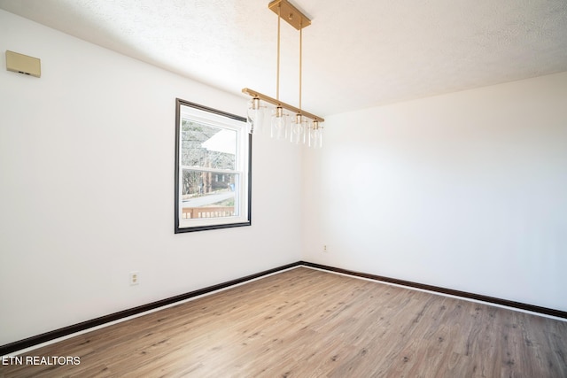 empty room featuring hardwood / wood-style flooring and a textured ceiling