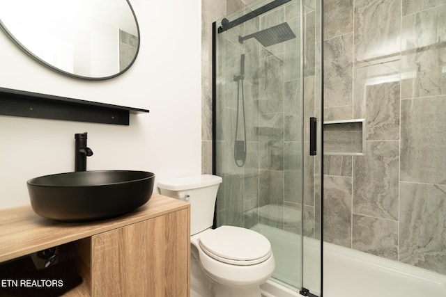 bathroom with vanity, toilet, and a shower with shower door