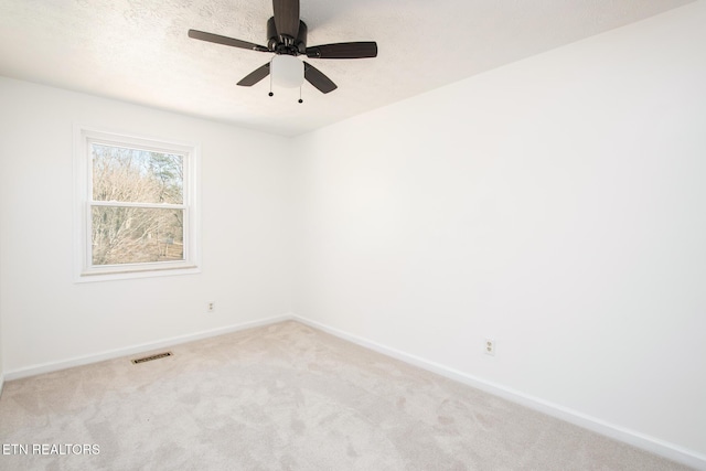 empty room featuring ceiling fan, a textured ceiling, and carpet