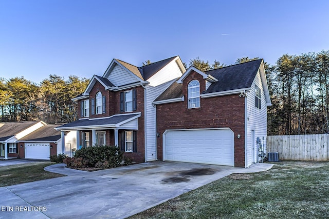 view of property with a garage, central AC, a front yard, and covered porch