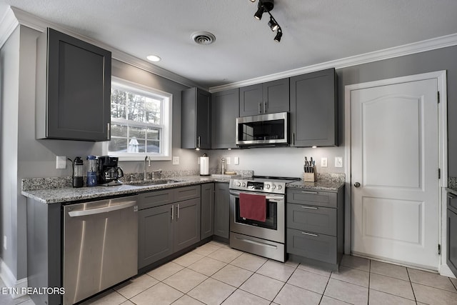 kitchen with gray cabinets, appliances with stainless steel finishes, sink, and light tile patterned floors