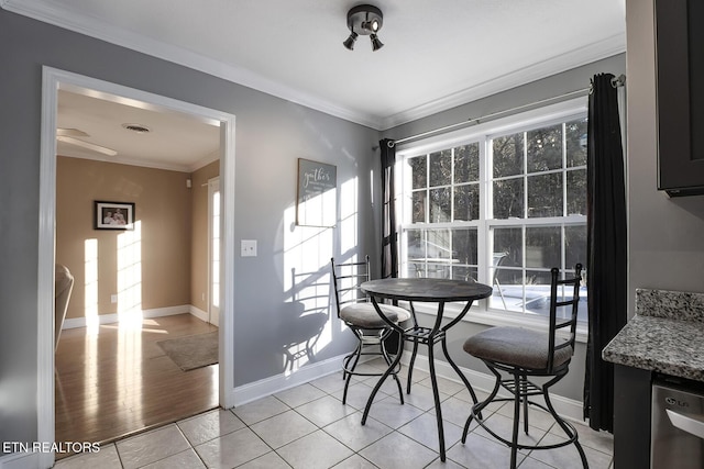 dining space with crown molding and light tile patterned floors