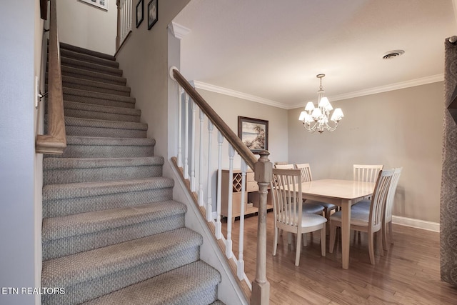 dining area with hardwood / wood-style flooring, crown molding, and a notable chandelier