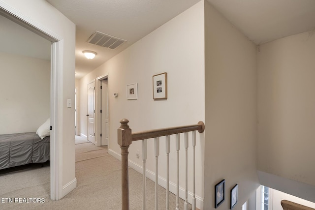 corridor featuring light colored carpet