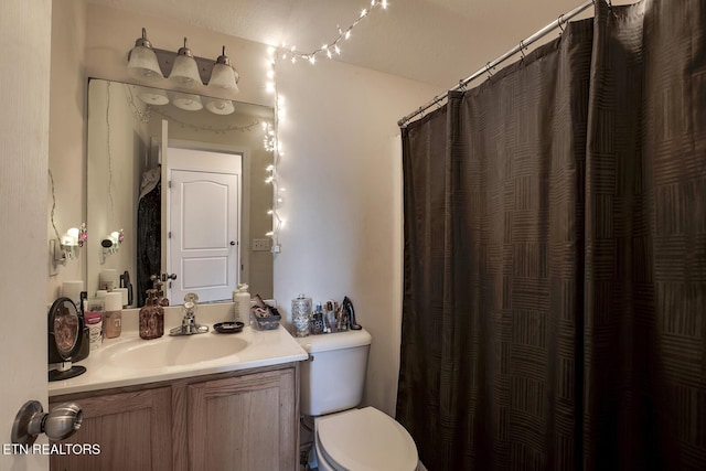 bathroom featuring vanity, a shower with curtain, and toilet