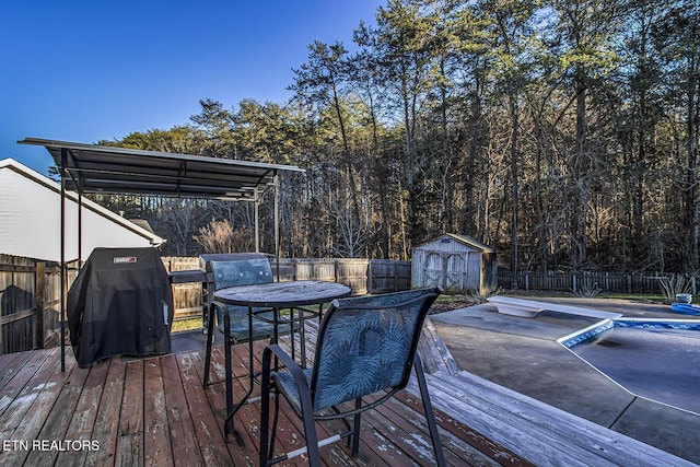 wooden deck featuring grilling area and a storage unit