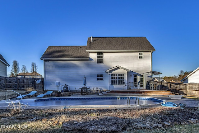 back of house featuring an empty pool