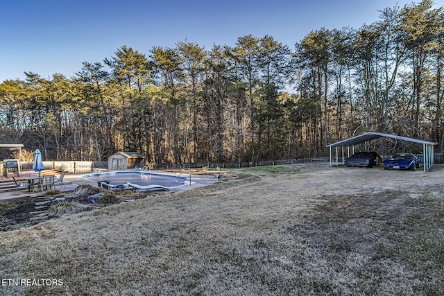 view of pool featuring a carport and a storage shed