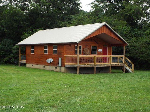 rear view of property featuring a deck and a lawn