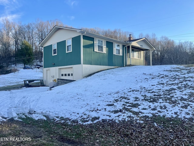 view of snow covered exterior with a garage