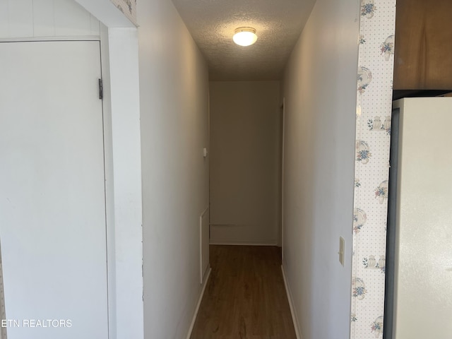 corridor with hardwood / wood-style flooring and a textured ceiling