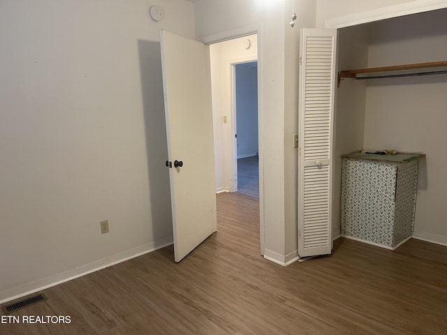 unfurnished bedroom featuring hardwood / wood-style flooring and a closet