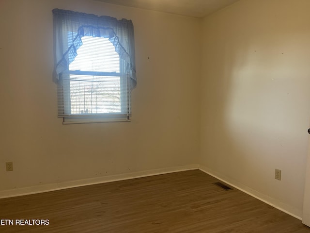 spare room with dark wood-type flooring