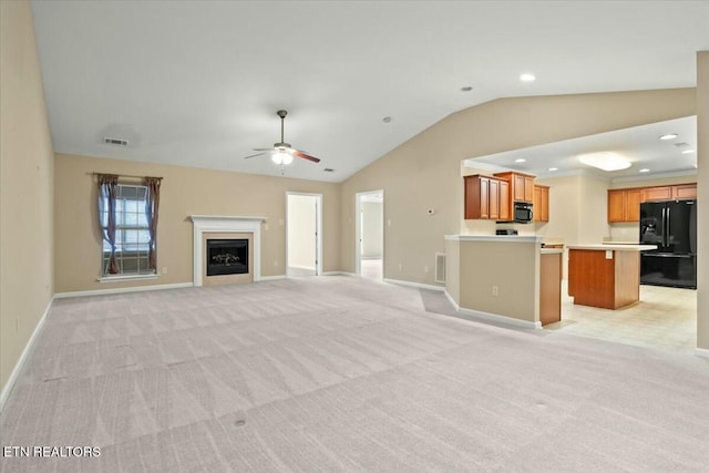 unfurnished living room with light carpet, vaulted ceiling, and ceiling fan