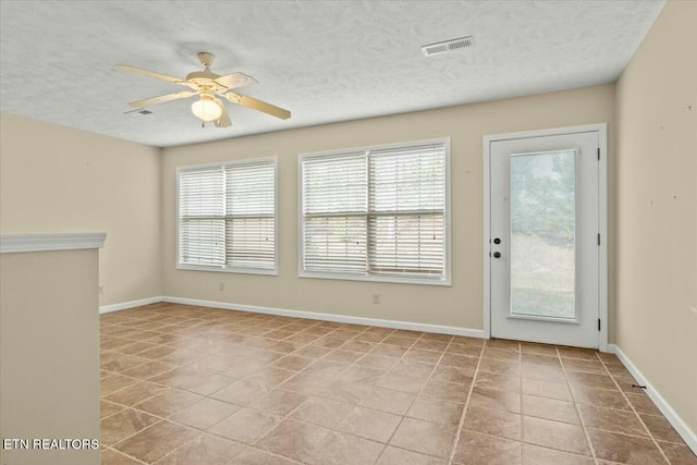 interior space with ceiling fan and a textured ceiling