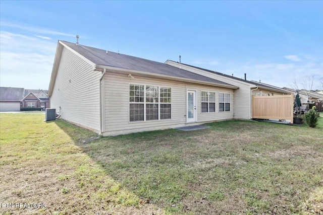 rear view of house featuring a yard and central AC